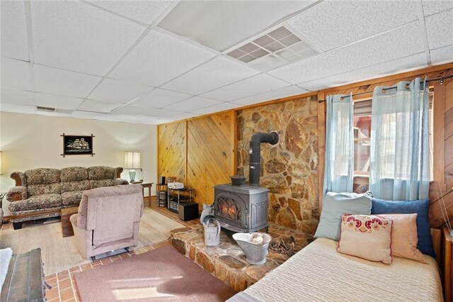 728 Tall Oak Trl, Seneca, SC 29678 - living room featuring a paneled ceiling, light hardwood / wood-style floors, wood walls, and a wood stove