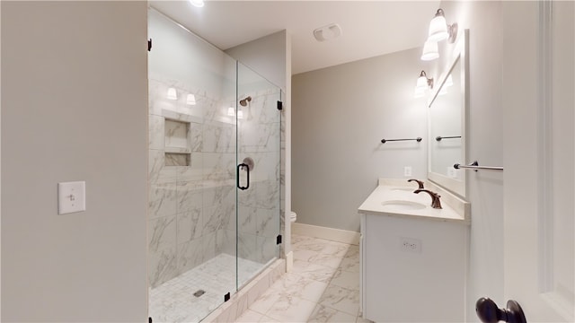 bathroom with toilet, vanity, and a shower with shower door