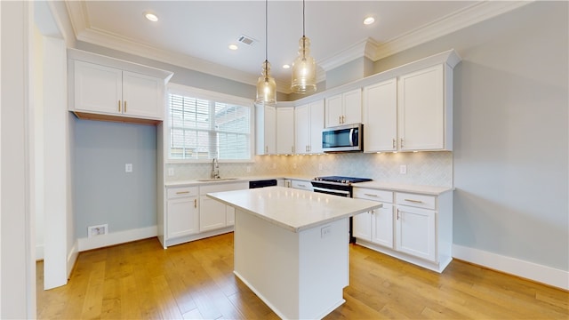 kitchen featuring appliances with stainless steel finishes, a kitchen island, light hardwood / wood-style floors, and white cabinets