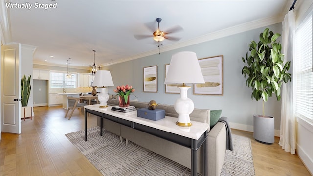 dining room featuring ornamental molding, light wood-type flooring, and ceiling fan