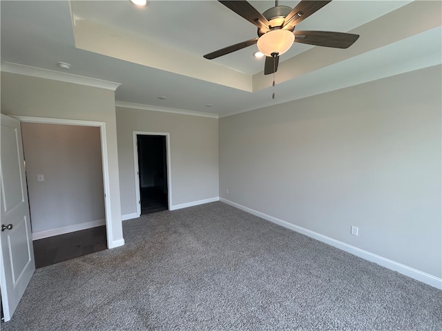 unfurnished bedroom with ornamental molding, ceiling fan, a raised ceiling, and carpet flooring