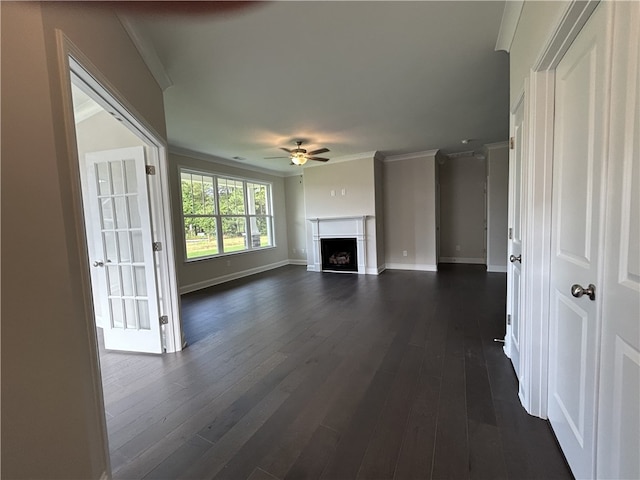 unfurnished living room featuring ornamental molding, ceiling fan, and dark hardwood / wood-style floors