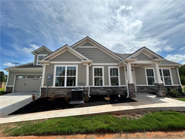 craftsman-style home with cooling unit and a garage