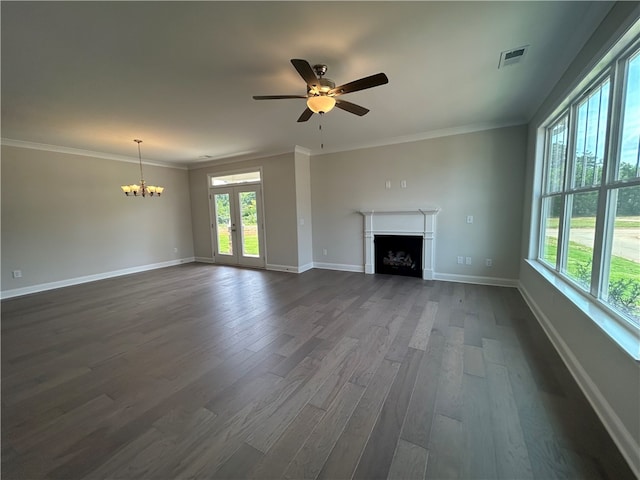 unfurnished living room with ornamental molding, ceiling fan with notable chandelier, and dark wood-type flooring