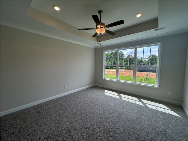 empty room featuring carpet, ceiling fan, and a tray ceiling