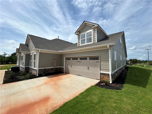 craftsman-style home with central AC, a front yard, and a garage