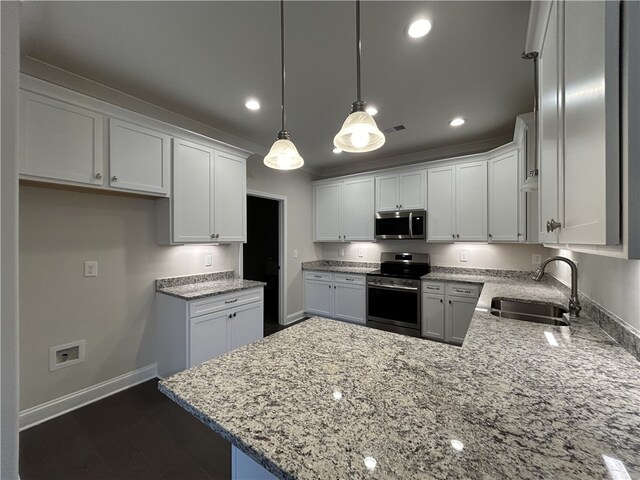 kitchen with sink, white cabinets, kitchen peninsula, stainless steel appliances, and decorative light fixtures