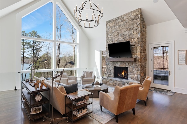 living room featuring hardwood / wood-style flooring, a stone fireplace, and high vaulted ceiling