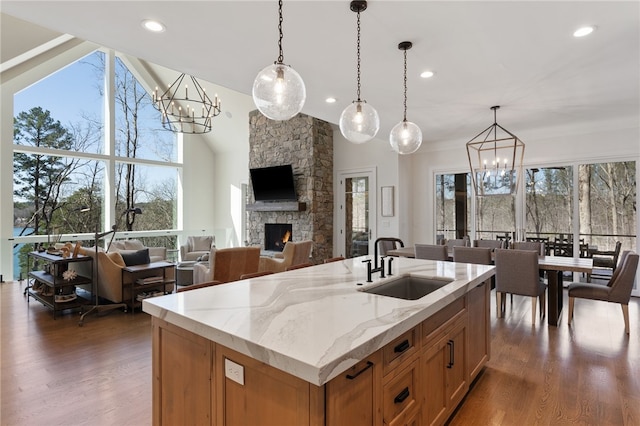 kitchen with decorative light fixtures, a stone fireplace, and a wealth of natural light