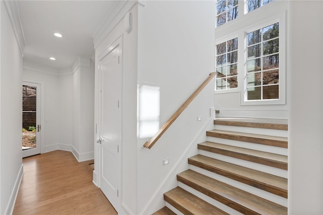 stairs featuring crown molding and hardwood / wood-style floors