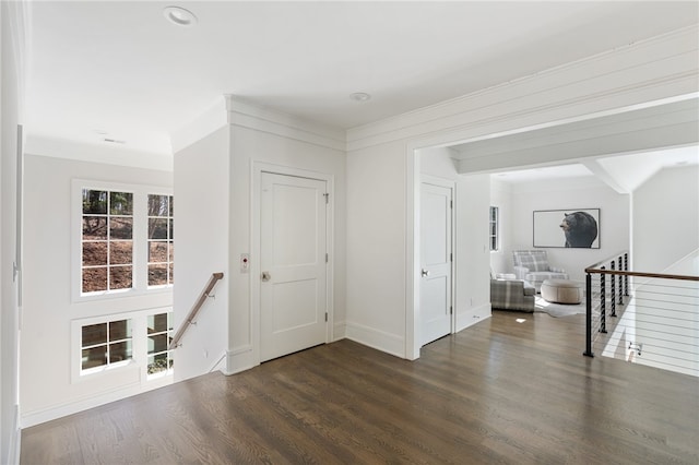 foyer entrance with dark wood-type flooring and ornamental molding