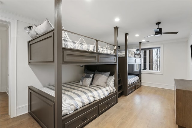 bedroom with ceiling fan, ornamental molding, and light hardwood / wood-style flooring