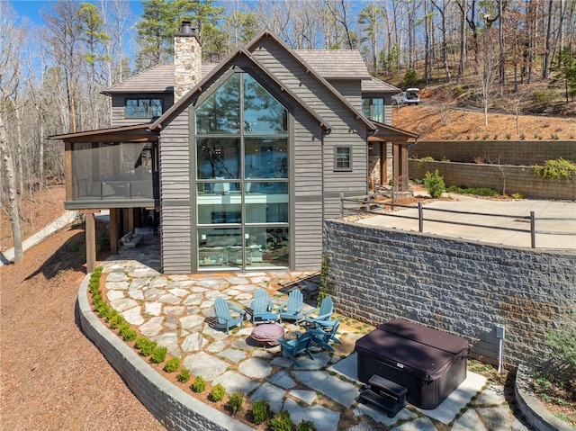 view of home's exterior featuring a patio, a hot tub, and a sunroom