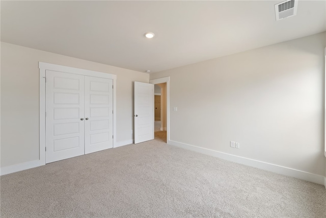 unfurnished bedroom with carpet flooring and a closet