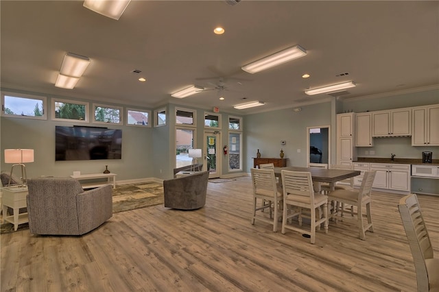 dining space featuring light hardwood / wood-style floors, ceiling fan, and crown molding