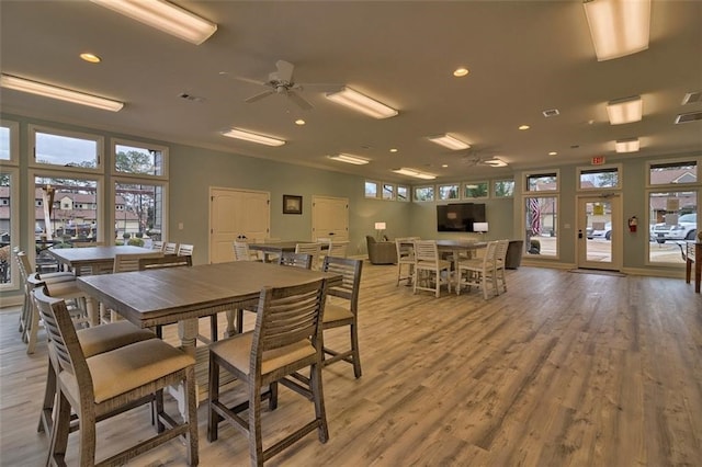 dining area with crown molding, ceiling fan, and light hardwood / wood-style flooring