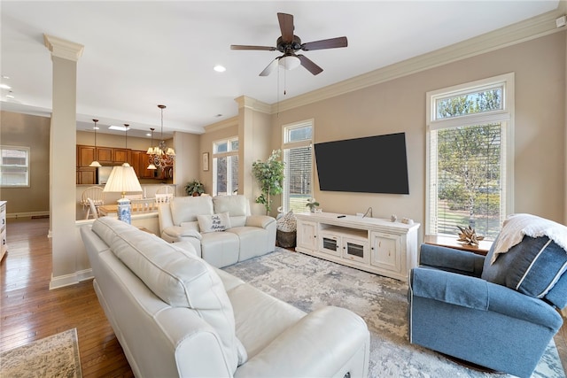 living room with ceiling fan with notable chandelier, light hardwood / wood-style floors, and a wealth of natural light