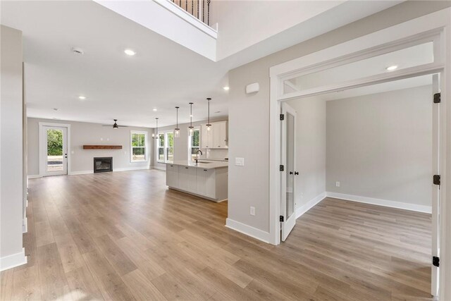 305 Breakwater Ln, Seneca, SC 29678 - unfurnished living room with light wood-style flooring, baseboards, a fireplace, and ceiling fan