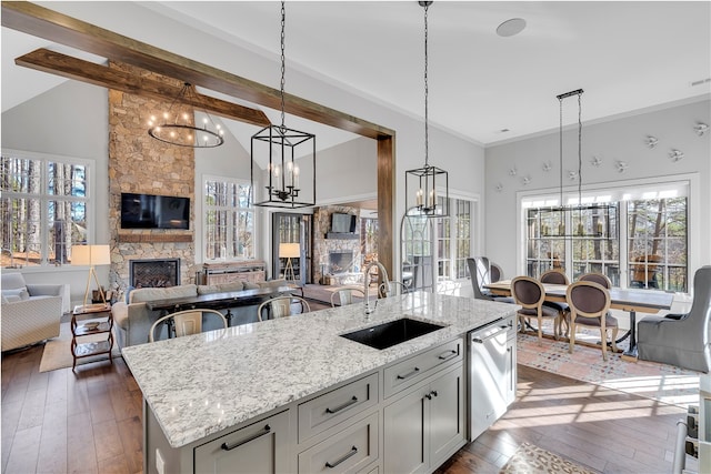 kitchen featuring a healthy amount of sunlight, a fireplace, sink, and decorative light fixtures