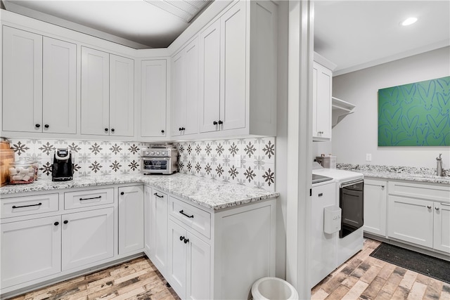 laundry room with sink, washing machine and clothes dryer, and light hardwood / wood-style flooring