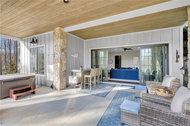 view of patio with ceiling fan and a hot tub