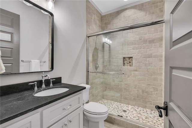 bathroom with a shower with door, vanity, and toilet