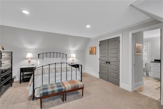 bedroom with light colored carpet, a closet, and vaulted ceiling