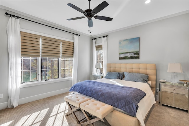 bedroom with multiple windows, light carpet, and ceiling fan