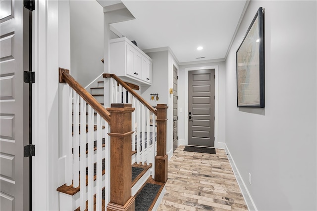 entrance foyer with light hardwood / wood-style flooring and ornamental molding