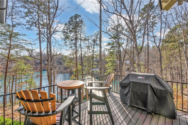 wooden terrace featuring a grill and a water view