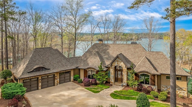 french country style house featuring a water view, stone siding, and stucco siding