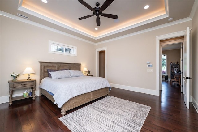 bedroom with baseboards, visible vents, a raised ceiling, and dark wood finished floors