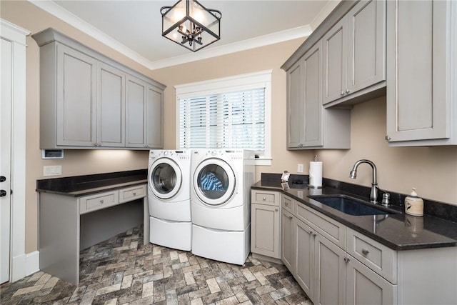 clothes washing area featuring cabinet space, washer and clothes dryer, ornamental molding, brick floor, and a sink