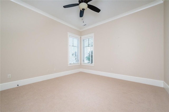 carpeted spare room with ceiling fan, baseboards, and crown molding