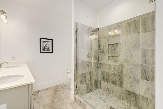 bathroom featuring vanity, toilet, and a shower with door