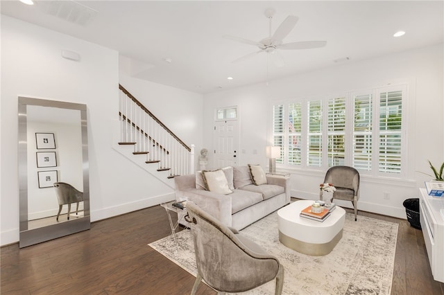 living room featuring ceiling fan and dark hardwood / wood-style floors