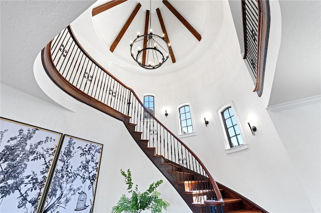 stairway featuring a high ceiling and a chandelier