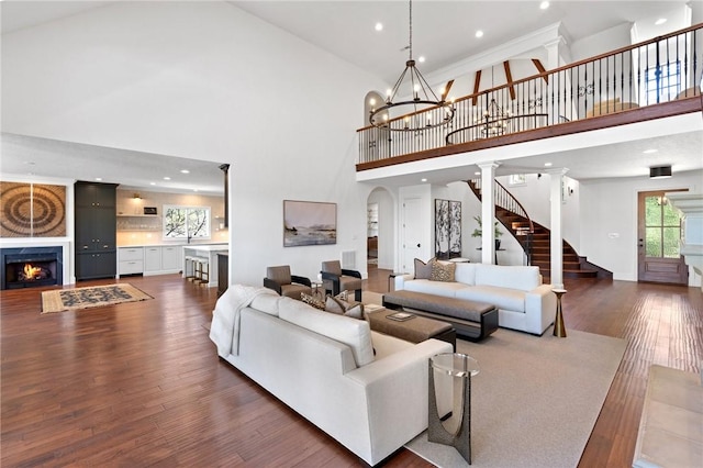 living room with a high ceiling, dark hardwood / wood-style floors, and a notable chandelier