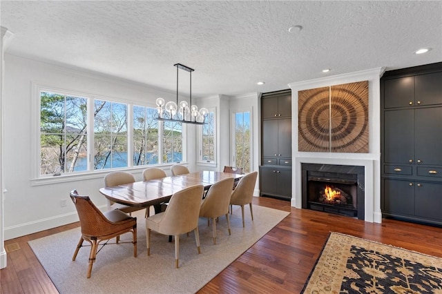 dining area with a textured ceiling, dark hardwood / wood-style floors, and ornamental molding