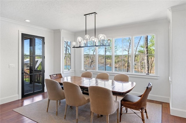 dining room with a notable chandelier, dark hardwood / wood-style floors, crown molding, and a textured ceiling