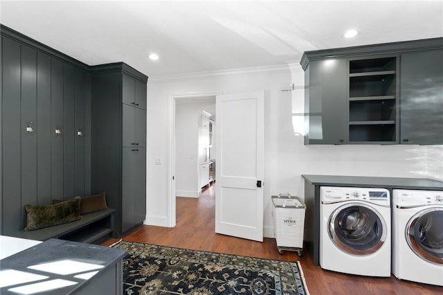 washroom with washer and dryer, dark hardwood / wood-style floors, cabinets, and ornamental molding