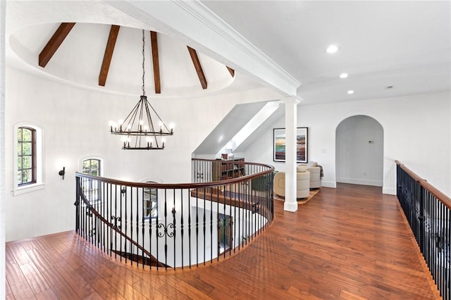 corridor with lofted ceiling with beams, dark wood-type flooring, and a notable chandelier