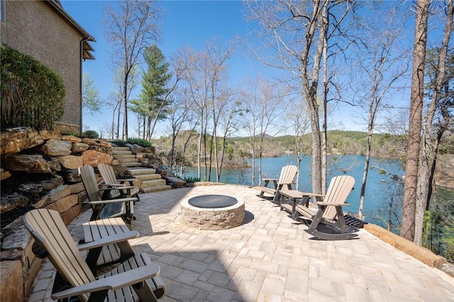 view of patio / terrace with a fire pit and a water view