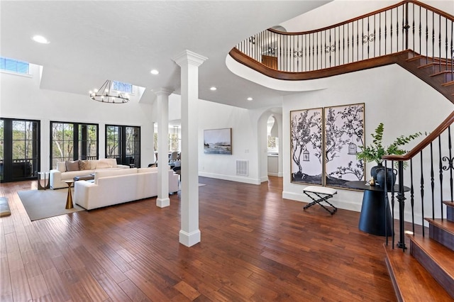 foyer with french doors, dark wood-type flooring, a high ceiling, and a notable chandelier