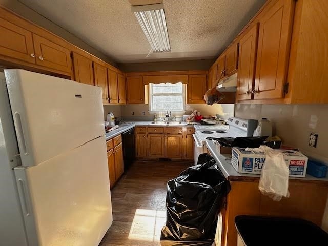 kitchen featuring a textured ceiling, white appliances, sink, and dark wood-type flooring