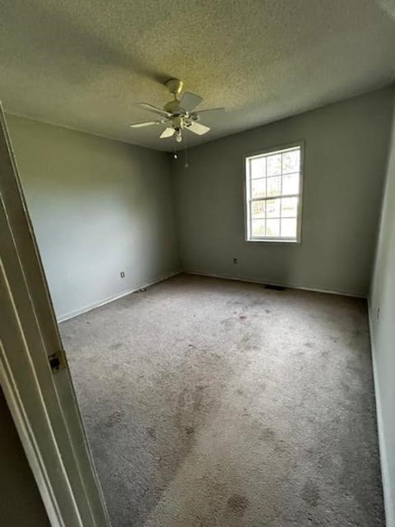 spare room with carpet floors, a textured ceiling, and ceiling fan