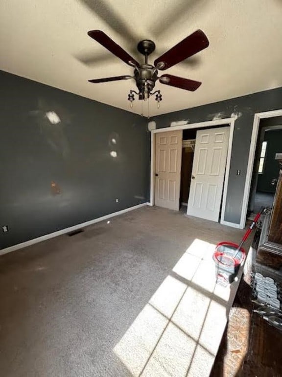 unfurnished bedroom featuring carpet floors, a textured ceiling, ceiling fan, and a closet