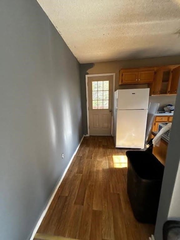 interior space with white refrigerator, hardwood / wood-style floors, and a textured ceiling