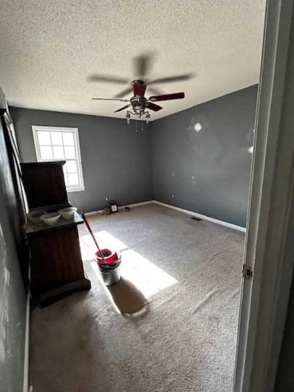 bedroom featuring ceiling fan, carpet floors, and a textured ceiling