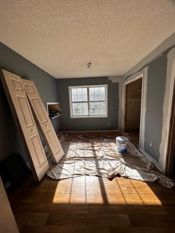 misc room with a textured ceiling and dark hardwood / wood-style flooring